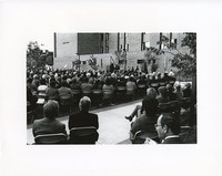 Walsh Hall exterior: dedication, crowd seated listening to speaker