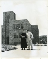 Fulton Hall exterior: Jesuit faculty member and student in front