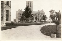 Gasson Hall exterior: front from side of Linden Lane lined with American flags and a crowd on the lawn