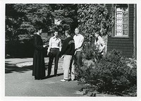 Saint Joseph&#39;s Hall exterior: side with priest and students talking close up