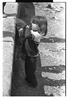 Traveler woman doing laundry in a tub, with children and others around, before being evicted, Newry, County Down