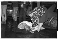 Injured woman receiving first aid from ambulance crew at a car accident, County Down