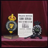 Original &quot;Dan Breen Wanted&quot; poster beside police crests from an earlier era, Royal Irish Constabulary and Irish Constabulary